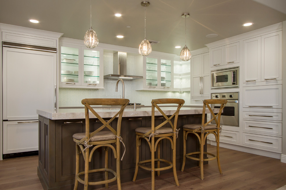 Eat-in kitchen - small transitional l-shaped light wood floor and brown floor eat-in kitchen idea in Phoenix with a single-bowl sink, shaker cabinets, white cabinets, quartz countertops, white backsplash, glass tile backsplash, stainless steel appliances, an island and white countertops