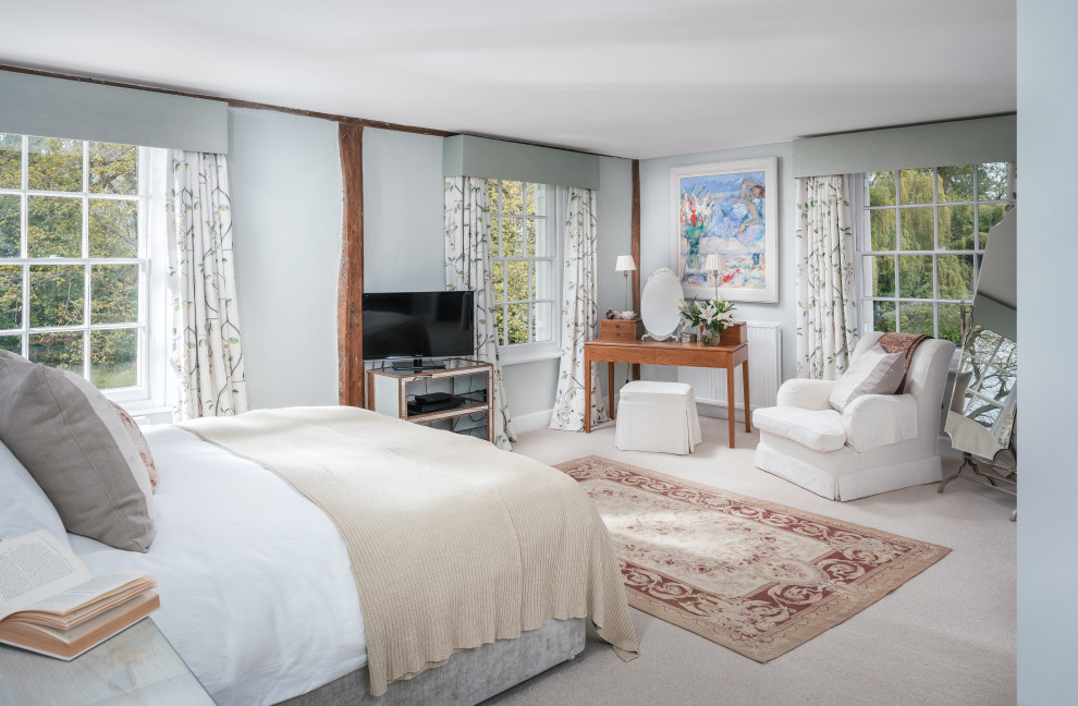 Großes Landhausstil Hauptschlafzimmer mit blauer Wandfarbe, Teppichboden und beigem Boden in Essex