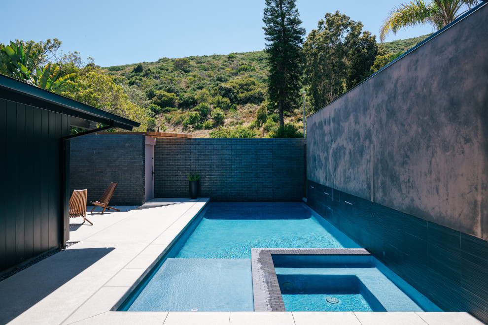 Cette image montre une piscine vintage de taille moyenne et rectangle avec des solutions pour vis-à-vis, une cour et une dalle de béton.