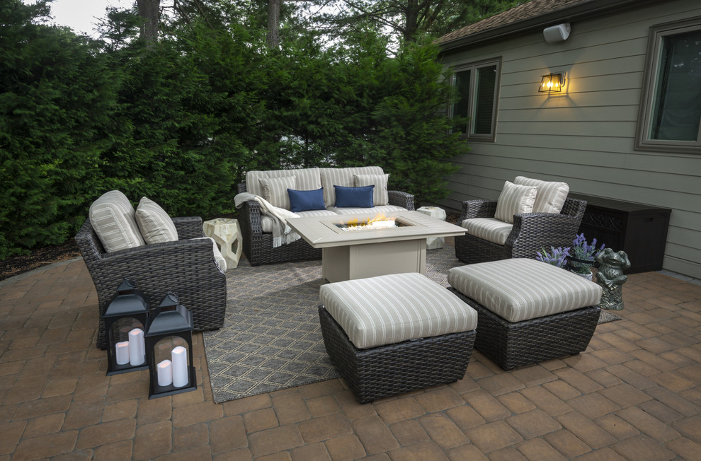 This is an example of a large transitional backyard patio in Philadelphia with a fire feature, brick pavers and no cover.
