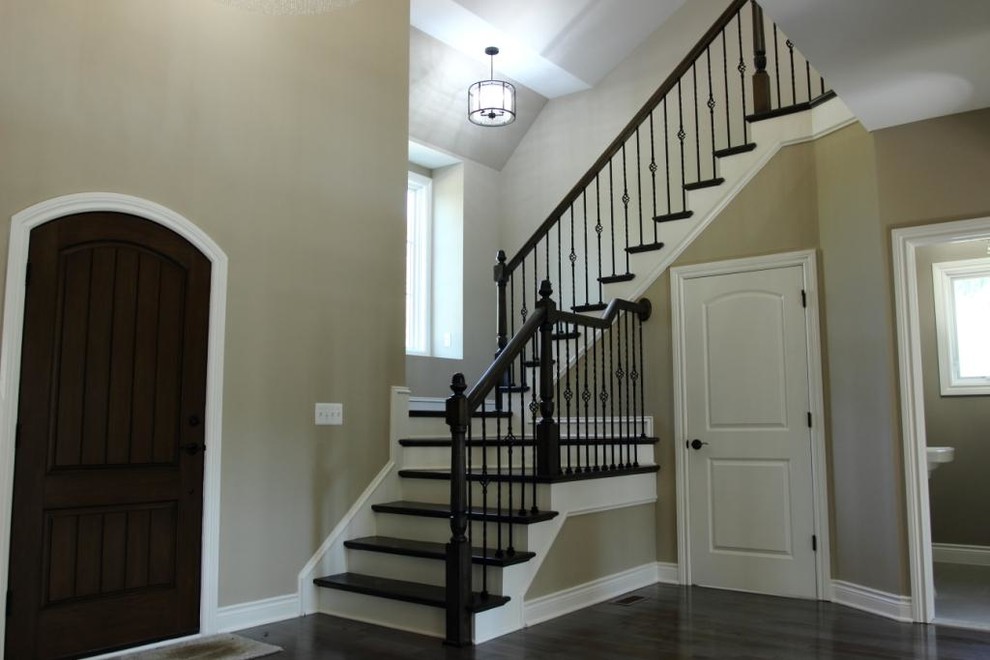 Photo of an expansive traditional wood l-shaped staircase in Detroit with painted wood risers.