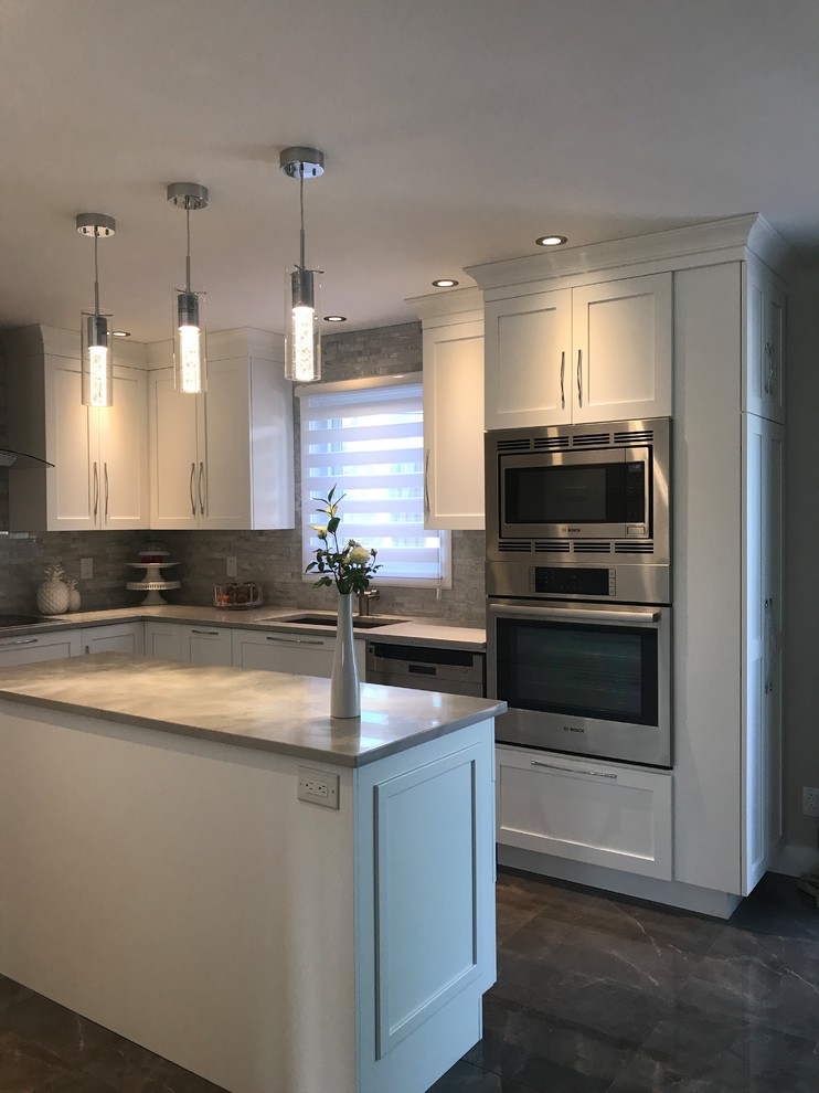 This is an example of a large transitional l-shaped kitchen in Montreal with an undermount sink, white cabinets, grey splashback, stainless steel appliances and with island.