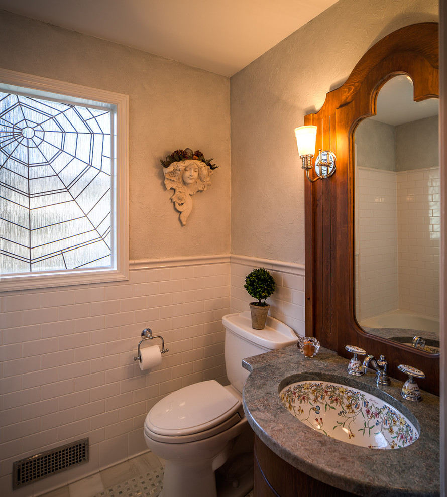 Photo of an eclectic bathroom in Chicago with an undermount sink, recessed-panel cabinets, dark wood cabinets, granite benchtops, a two-piece toilet, white tile and subway tile.