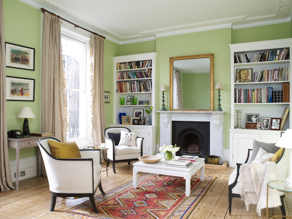 This is an example of a mid-sized traditional formal living room in New York with green walls, light hardwood floors, a standard fireplace, a stone fireplace surround and no tv.