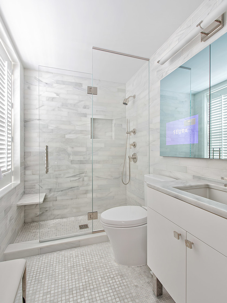 Photo of a small contemporary master bathroom in New York with an undermount sink, white cabinets, marble benchtops, white tile, stone tile, marble floors and flat-panel cabinets.