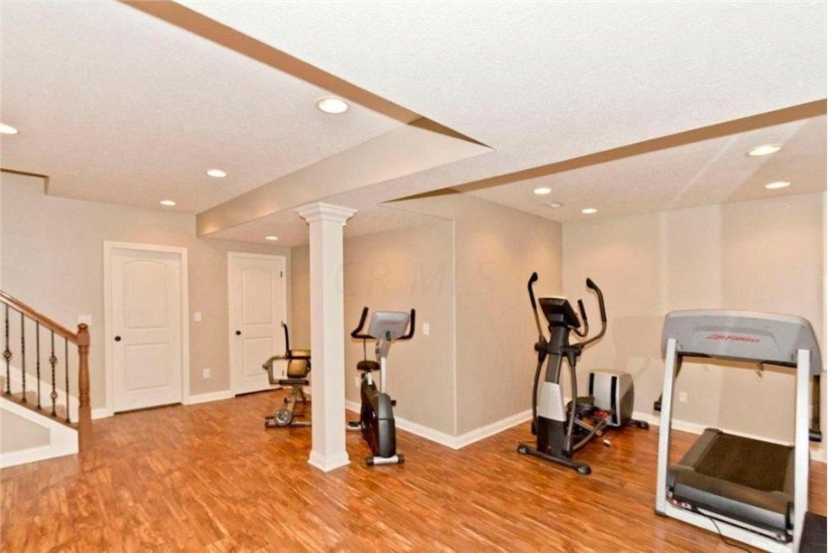 This is an example of a large traditional home yoga studio in Columbus with beige walls and light hardwood floors.