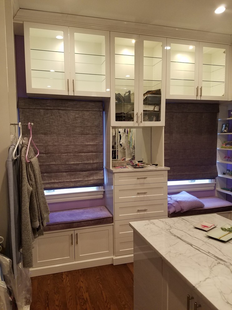 Design ideas for a large contemporary storage and wardrobe in New York with shaker cabinets, white cabinets, dark hardwood floors and brown floor.