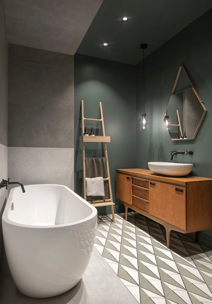Photo of a large scandinavian master bathroom in Saint Petersburg with a freestanding tub, green walls, cement tiles, a vessel sink, wood benchtops, multi-coloured floor, medium wood cabinets, gray tile, porcelain tile, flat-panel cabinets and brown benchtops.