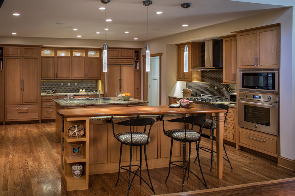 Photo of a transitional kitchen in Other with an undermount sink, flat-panel cabinets, medium wood cabinets, stainless steel appliances, medium hardwood floors, multiple islands and marble benchtops.
