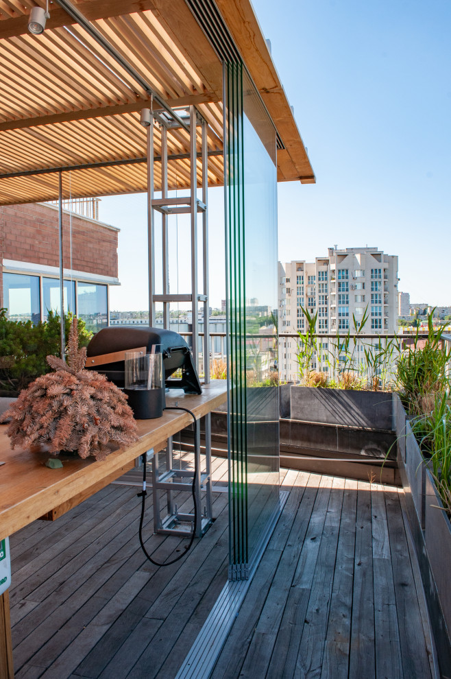 Photo of a mid-sized contemporary rooftop deck in Moscow with with privacy feature and a roof extension.