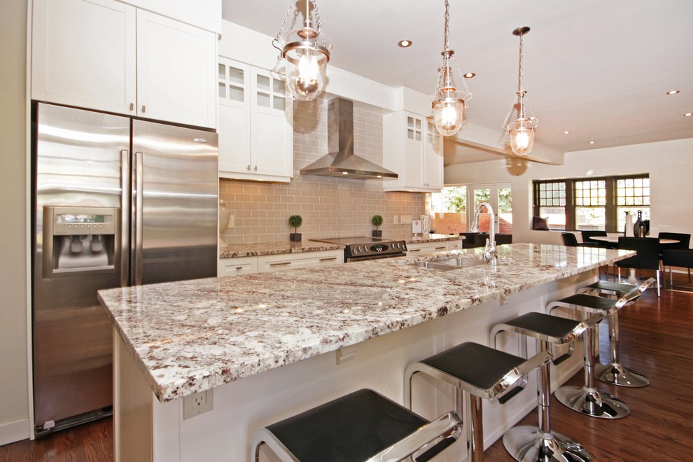 Inspiration for a mid-sized transitional single-wall medium tone wood floor eat-in kitchen remodel in Calgary with a double-bowl sink, white cabinets, granite countertops, stainless steel appliances and an island