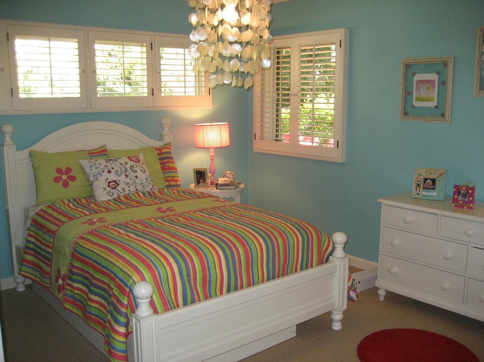 This is an example of a large contemporary kids' bedroom for kids 4-10 years old and girls in Los Angeles with blue walls, carpet and beige floor.