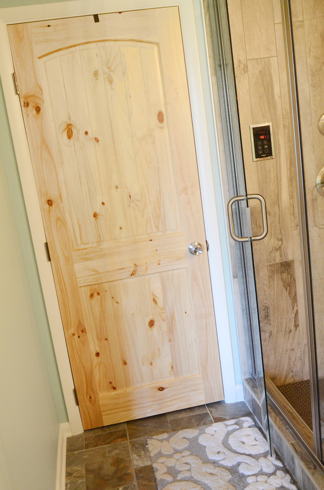 Photo of a small country 3/4 bathroom in Columbus with medium hardwood floors, an alcove shower, blue walls and a hinged shower door.