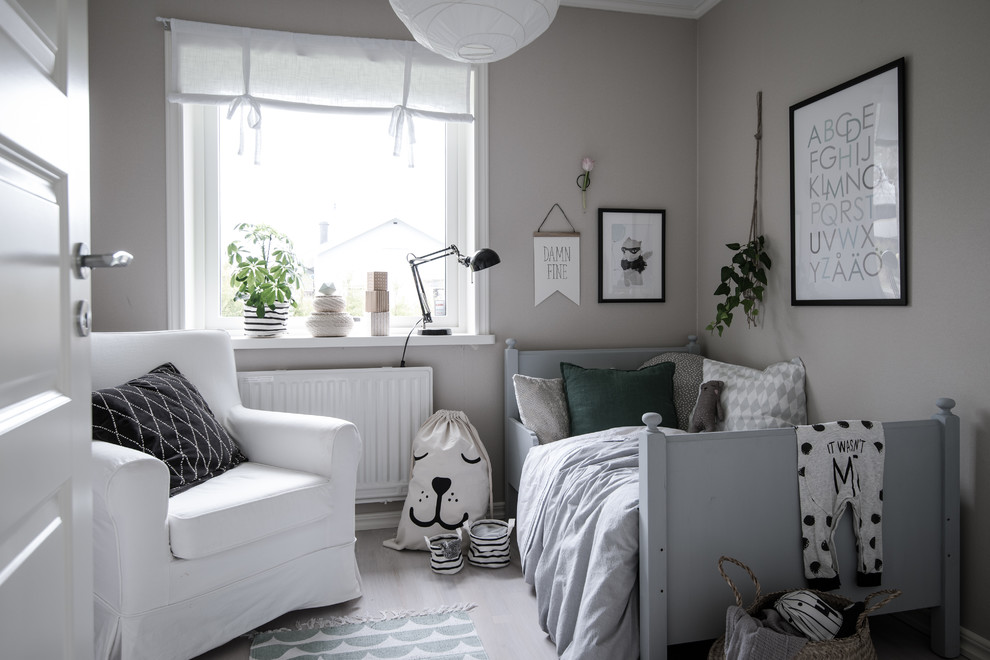 Photo of a scandinavian gender-neutral kids' bedroom for kids 4-10 years old in Gothenburg with grey walls and dark hardwood floors.