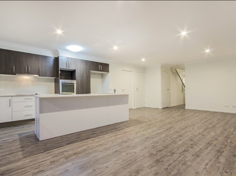 Contemporary kitchen in Gold Coast - Tweed with white splashback, light hardwood floors and with island.