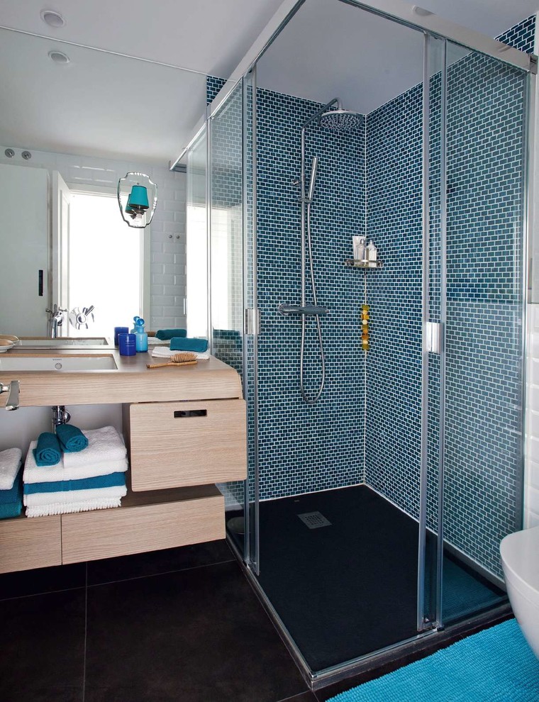 Design ideas for a mid-sized eclectic 3/4 bathroom in Madrid with an undermount sink, flat-panel cabinets, light wood cabinets, a corner shower, blue tile, ceramic tile, ceramic floors, wood benchtops and blue walls.