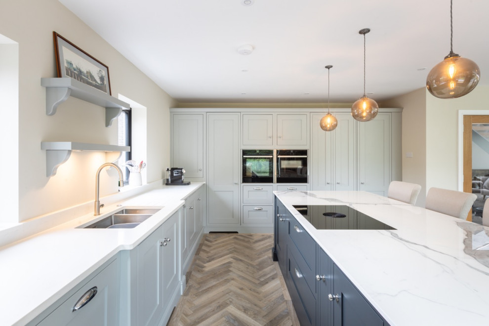 This is an example of a large modern l-shaped open plan kitchen in Sussex with shaker cabinets, grey cabinets, quartzite benchtops, with island and white benchtop.