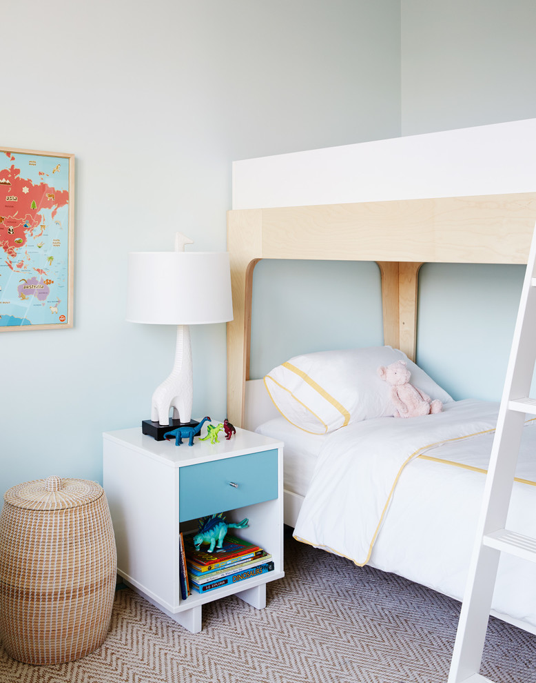 Design ideas for a transitional gender-neutral kids' bedroom for kids 4-10 years old in New York with blue walls and carpet.