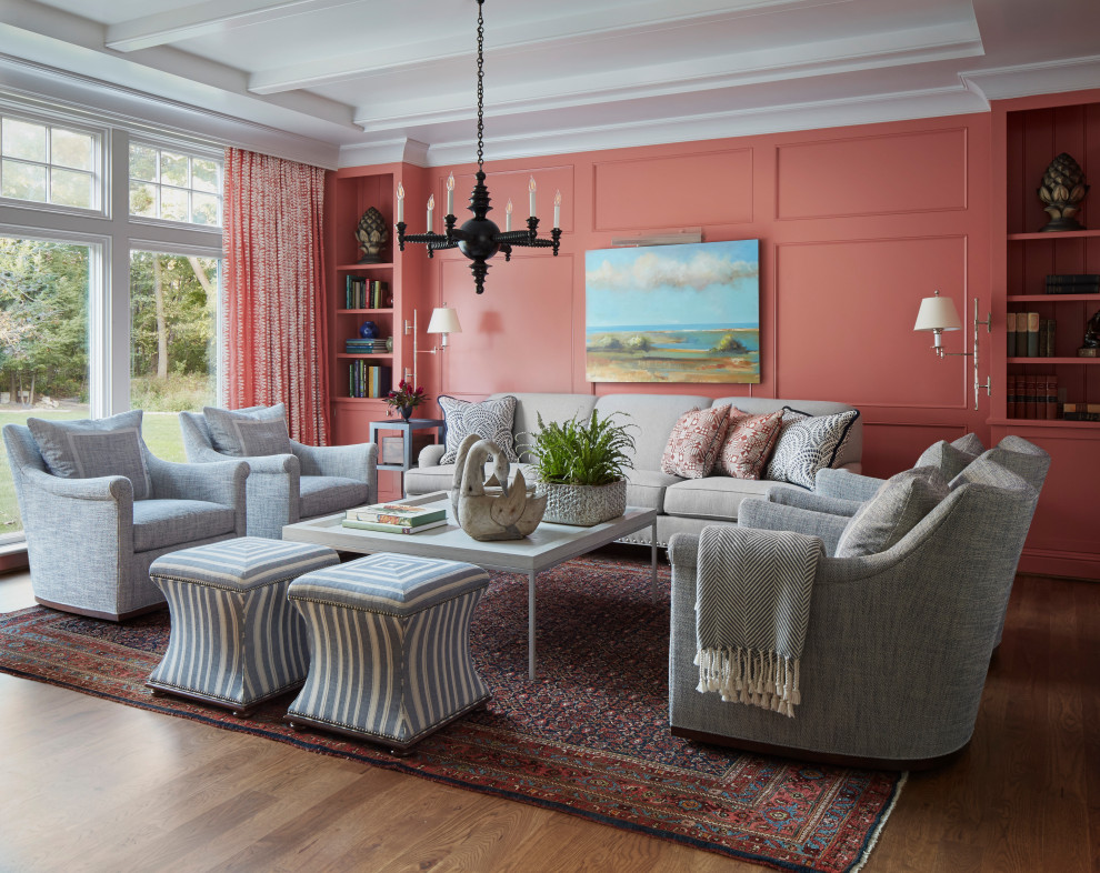 Идея дизайна: открытая гостиная комната в классическом стиле с розовыми стенами, паркетным полом среднего тона, двусторонним камином, фасадом камина из камня, коричневым полом, многоуровневым потолком и панелями на части стены