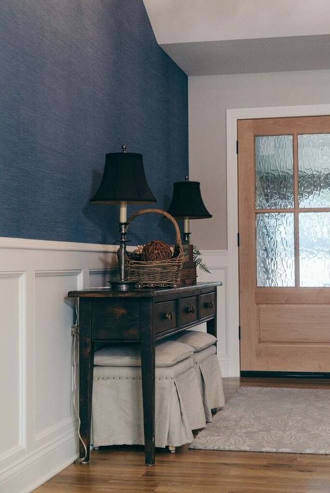Example of a mid-sized light wood floor and brown floor foyer design with blue walls and a brown front door