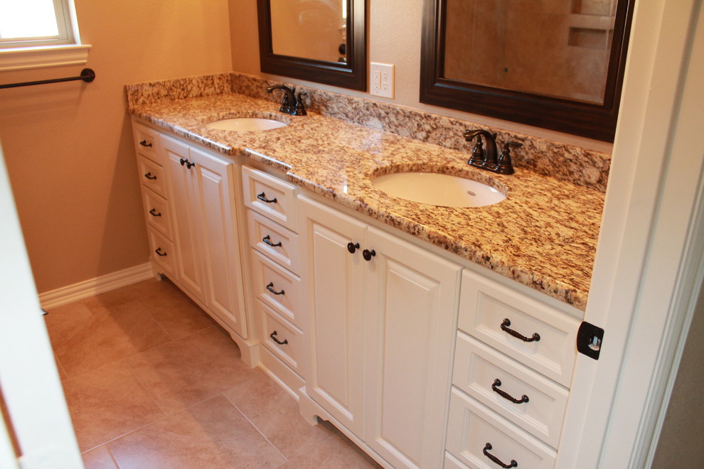 Mid-sized traditional kids bathroom in Dallas with an undermount sink, furniture-like cabinets, white cabinets, granite benchtops, an alcove tub, beige tile, glass tile, beige walls and ceramic floors.