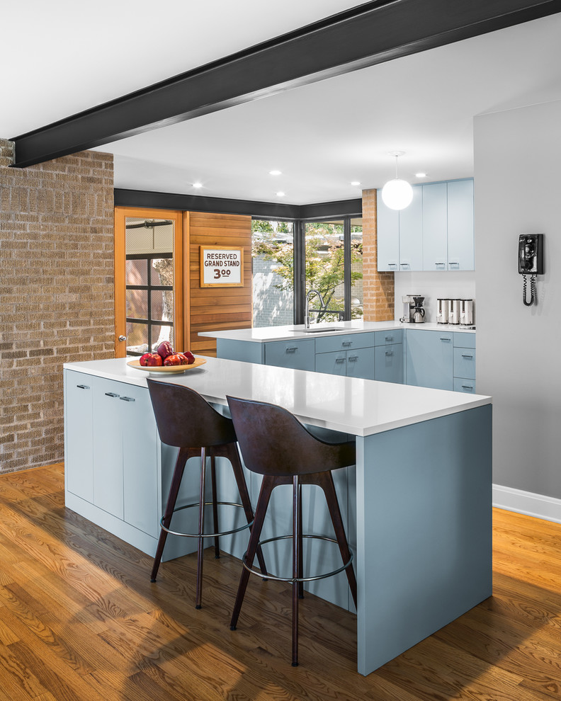 Inspiration for a contemporary l-shaped kitchen in Austin with flat-panel cabinets, blue cabinets, white splashback, medium hardwood floors and with island.