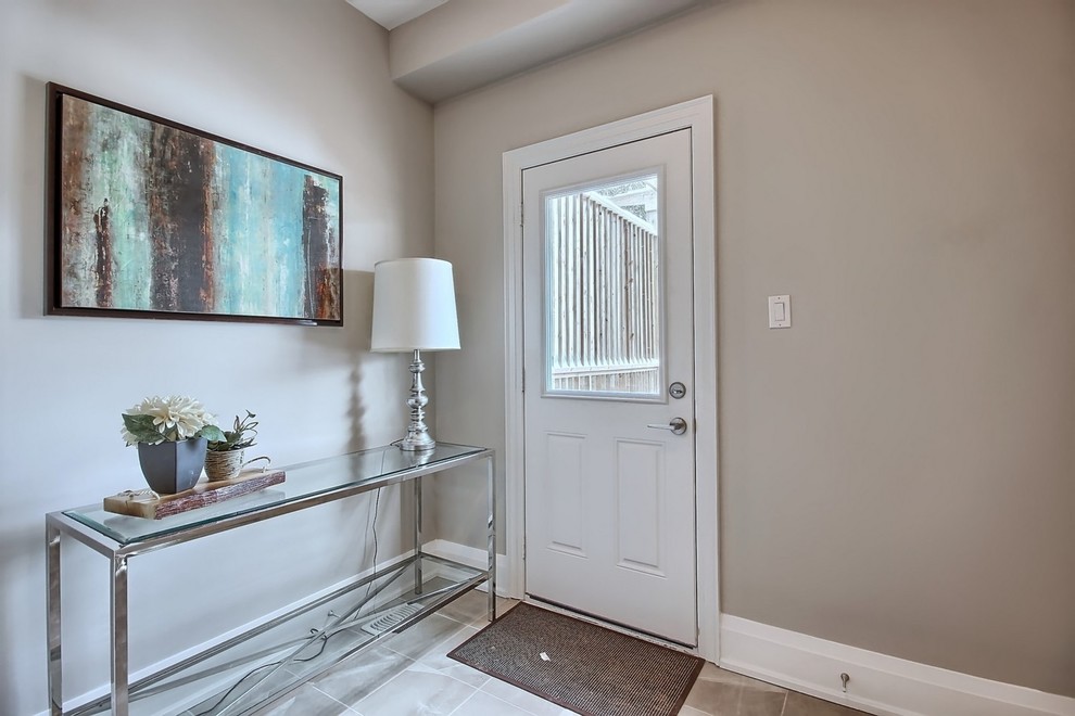 Photo of a mid-sized traditional mudroom in Toronto with beige walls, porcelain floors, a single front door and a white front door.