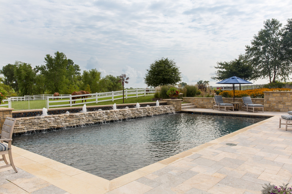 Large backyard rectangular natural pool in Kansas City with a water feature.