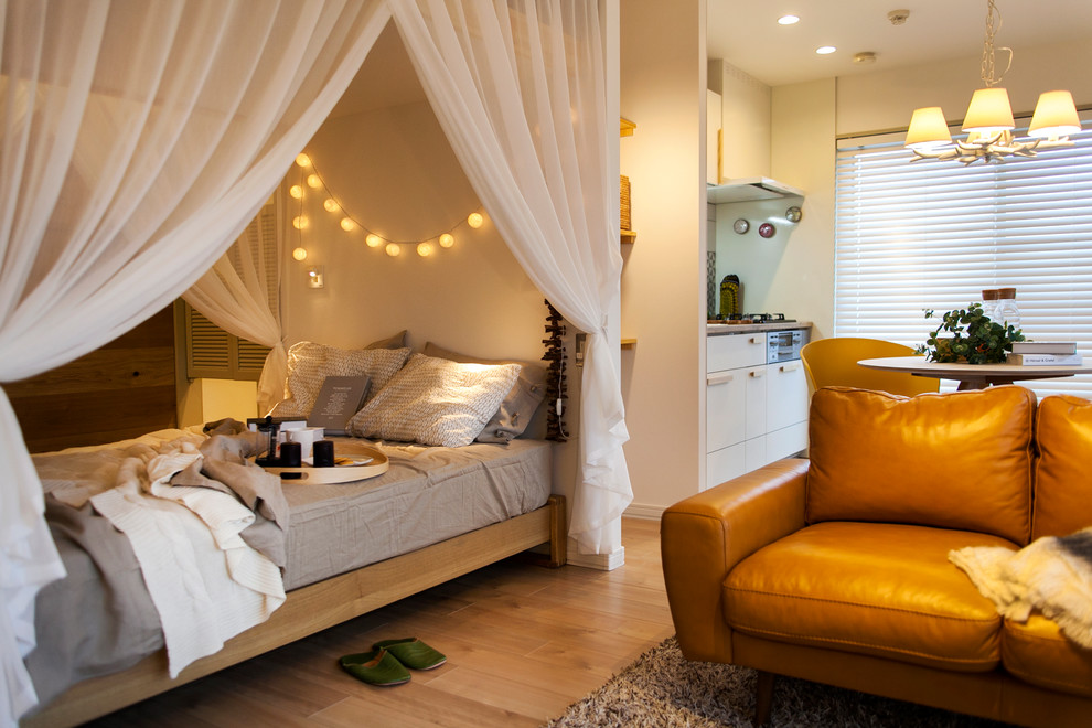 На фото: маленькая спальня в скандинавском стиле с белыми стенами, светлым паркетным полом и коричневым полом для на участке и в саду