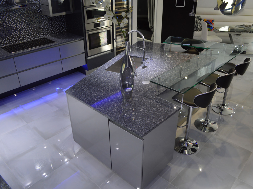 Inspiration for a large modern u-shaped porcelain tile eat-in kitchen remodel with an undermount sink, flat-panel cabinets, gray cabinets, quartz countertops, metallic backsplash, glass sheet backsplash, stainless steel appliances and an island