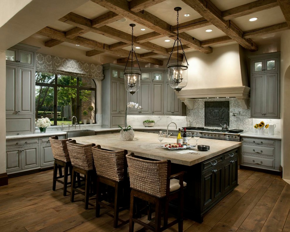 Inspiration for a mediterranean l-shaped kitchen in Phoenix with a farmhouse sink, raised-panel cabinets, grey cabinets, white splashback, stainless steel appliances, dark hardwood floors and with island.