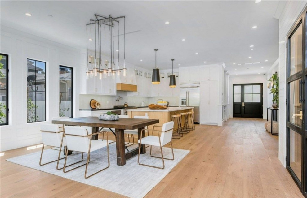 Large modern kitchen/dining combo in Los Angeles with light hardwood floors and brown floor.