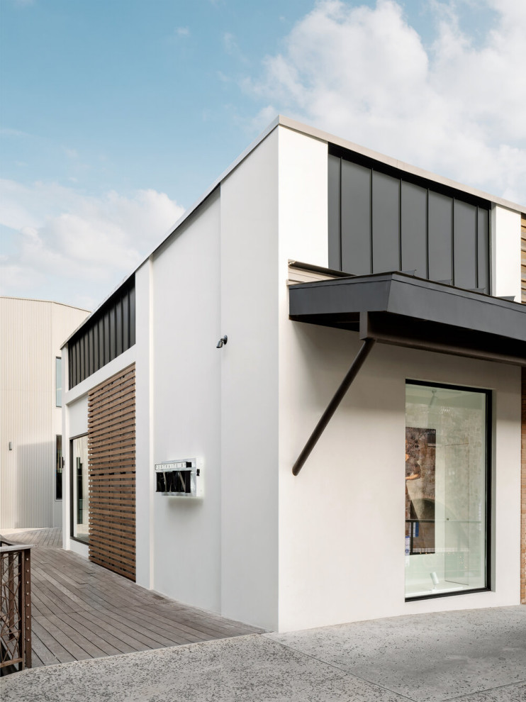 На фото: одноэтажный дом среднего размера в современном стиле с плоской крышей