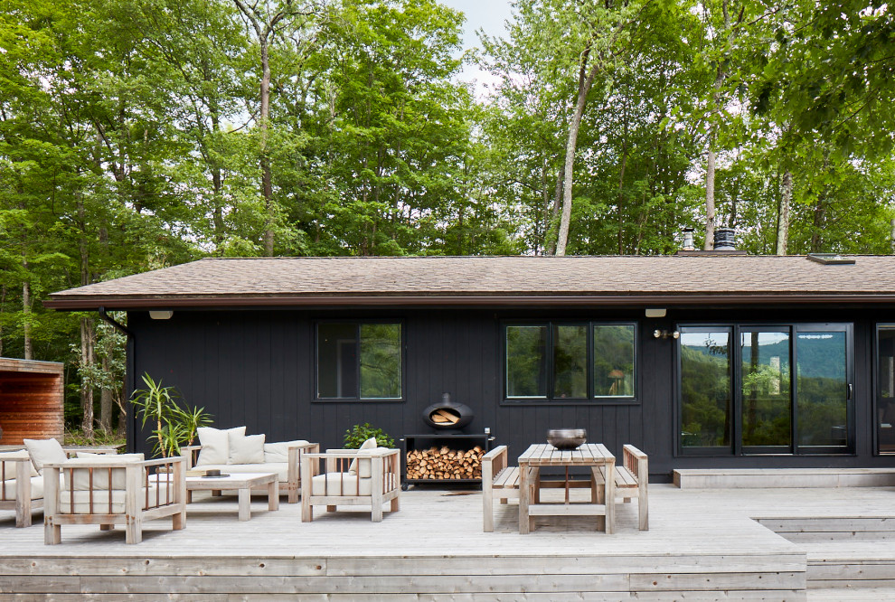 Design ideas for a large scandinavian backyard deck in New York with a roof extension.