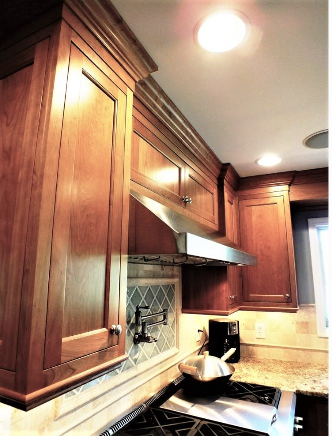 Large transitional u-shaped cork floor kitchen photo with beaded inset cabinets, medium tone wood cabinets, granite countertops, blue backsplash, stone tile backsplash, stainless steel appliances and an island