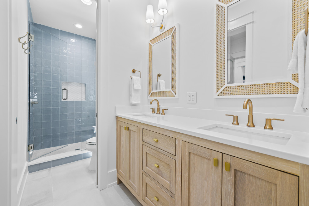Bild på ett mellanstort maritimt vit vitt badrum, med skåp i shakerstil, skåp i ljust trä, blå kakel, perrakottakakel, vita väggar, klinkergolv i porslin, ett undermonterad handfat, bänkskiva i kvartsit, vitt golv och dusch med gångjärnsdörr
