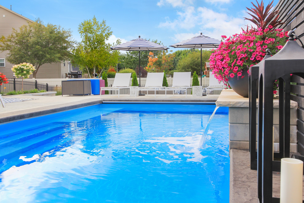 Example of a large transitional backyard stamped concrete and rectangular lap pool fountain design in Chicago