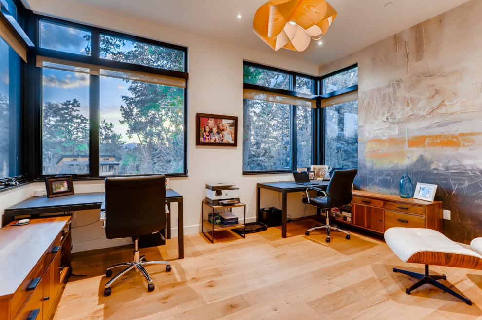 Photo of a mid-sized modern study room in Denver with light hardwood floors, a freestanding desk and brown floor.