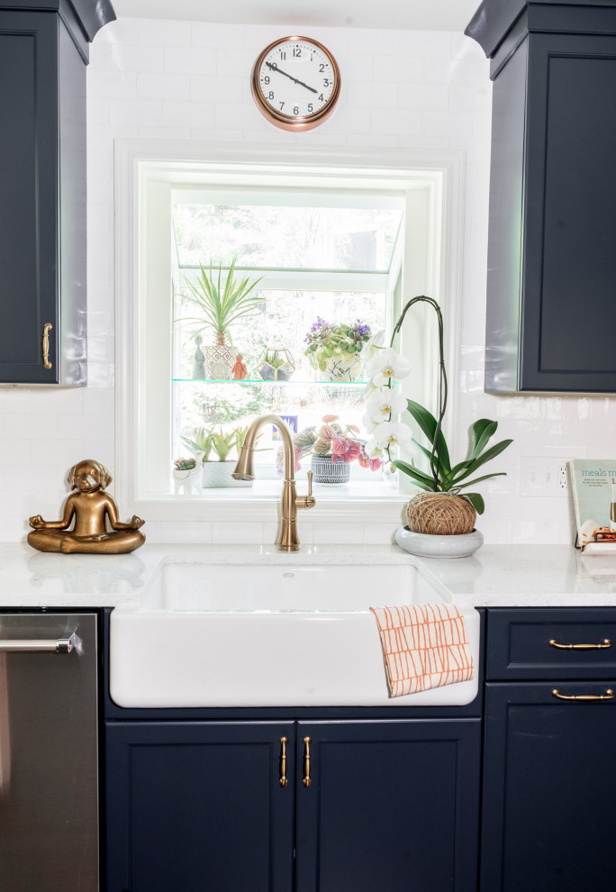 Small eclectic l-shaped eat-in kitchen in Atlanta with a farmhouse sink, shaker cabinets, blue cabinets, quartz benchtops, blue splashback, ceramic splashback, stainless steel appliances, medium hardwood floors, a peninsula, brown floor and blue benchtop.