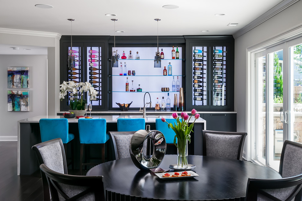 Expansive modern galley seated home bar with dark hardwood floors, brown floor, an undermount sink, flat-panel cabinets, black cabinets, quartz benchtops, blue benchtop and glass sheet splashback.
