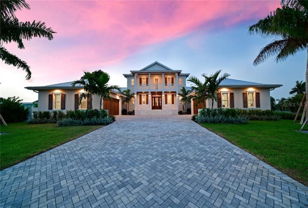 Photo of a large beach style three-storey house exterior in Tampa with a metal roof.
