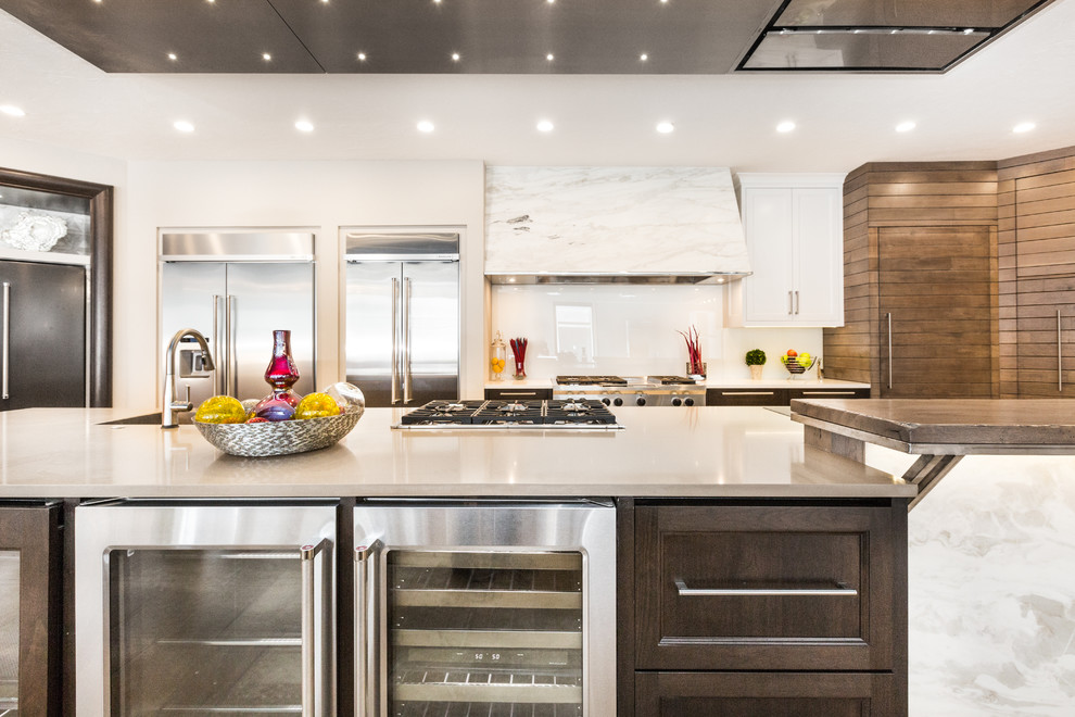 Huge transitional limestone floor kitchen photo in Albuquerque with an undermount sink, white backsplash, glass sheet backsplash and an island