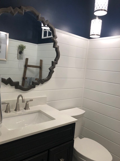 Bathroom - mid-sized transitional 3/4 porcelain floor and beige floor bathroom idea in DC Metro with recessed-panel cabinets, black cabinets, a two-piece toilet, blue walls, an undermount sink, engineered quartz countertops and white countertops