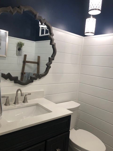 This is an example of a medium sized traditional shower room bathroom in DC Metro with recessed-panel cabinets, black cabinets, a two-piece toilet, blue walls, porcelain flooring, a submerged sink, engineered stone worktops, beige floors and white worktops.