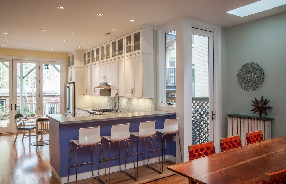Inspiration for a mid-sized contemporary galley eat-in kitchen in DC Metro with an undermount sink, shaker cabinets, white cabinets, quartz benchtops, white splashback, glass tile splashback, stainless steel appliances, medium hardwood floors and a peninsula.