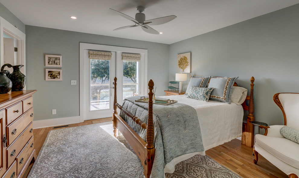 Mid-sized beach style guest bedroom in Other with grey walls and light hardwood floors.