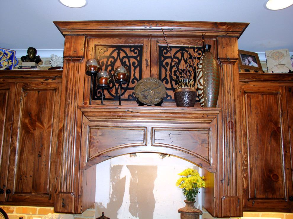 Example of a mid-sized galley medium tone wood floor and brown floor kitchen design in Atlanta with an undermount sink, raised-panel cabinets, medium tone wood cabinets, granite countertops, stainless steel appliances, an island and multicolored countertops