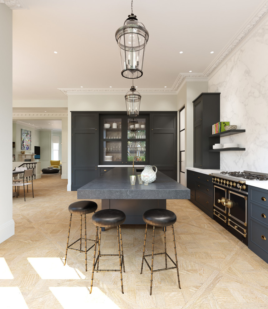 This is an example of a mid-sized transitional l-shaped kitchen in London with shaker cabinets, grey cabinets, with island, beige floor, an undermount sink, white splashback and black appliances.