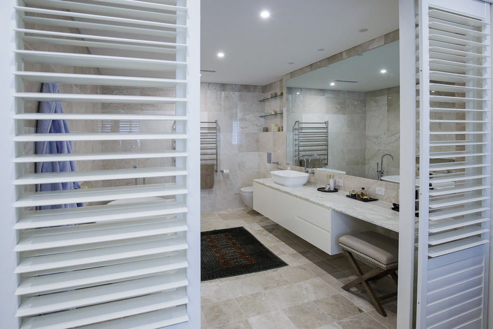 Inspiration for an expansive contemporary master bathroom in Sydney with flat-panel cabinets, beige cabinets, a freestanding tub, beige tile, ceramic tile, ceramic floors, engineered quartz benchtops and beige floor.