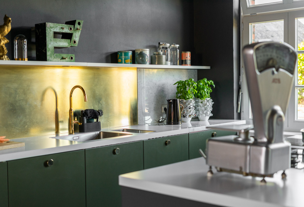 Inspiration for a small industrial galley open plan kitchen in Dortmund with a double-bowl sink, flat-panel cabinets, green cabinets, marble benchtops, metallic splashback, marble splashback, panelled appliances, ceramic floors, with island, black floor and white benchtop.